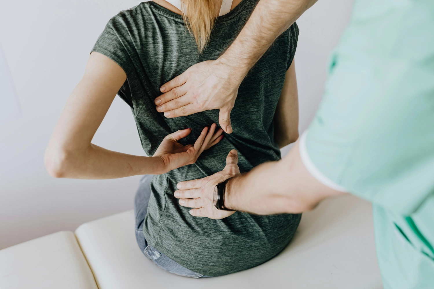 Osteopathie am Park – Ganzheitliche Behandlung – Das Bild zeigt einen Therapeuten, der eine körperliche Untersuchung oder manuelle Therapie am Rücken einer Person durchführt. Diese Interaktion entspricht Ansätzen zur Behandlung von Beschwerden des Bewegungsapparates wie Rückenschmerzen, Muskelverspannungen oder Gelenksteife.