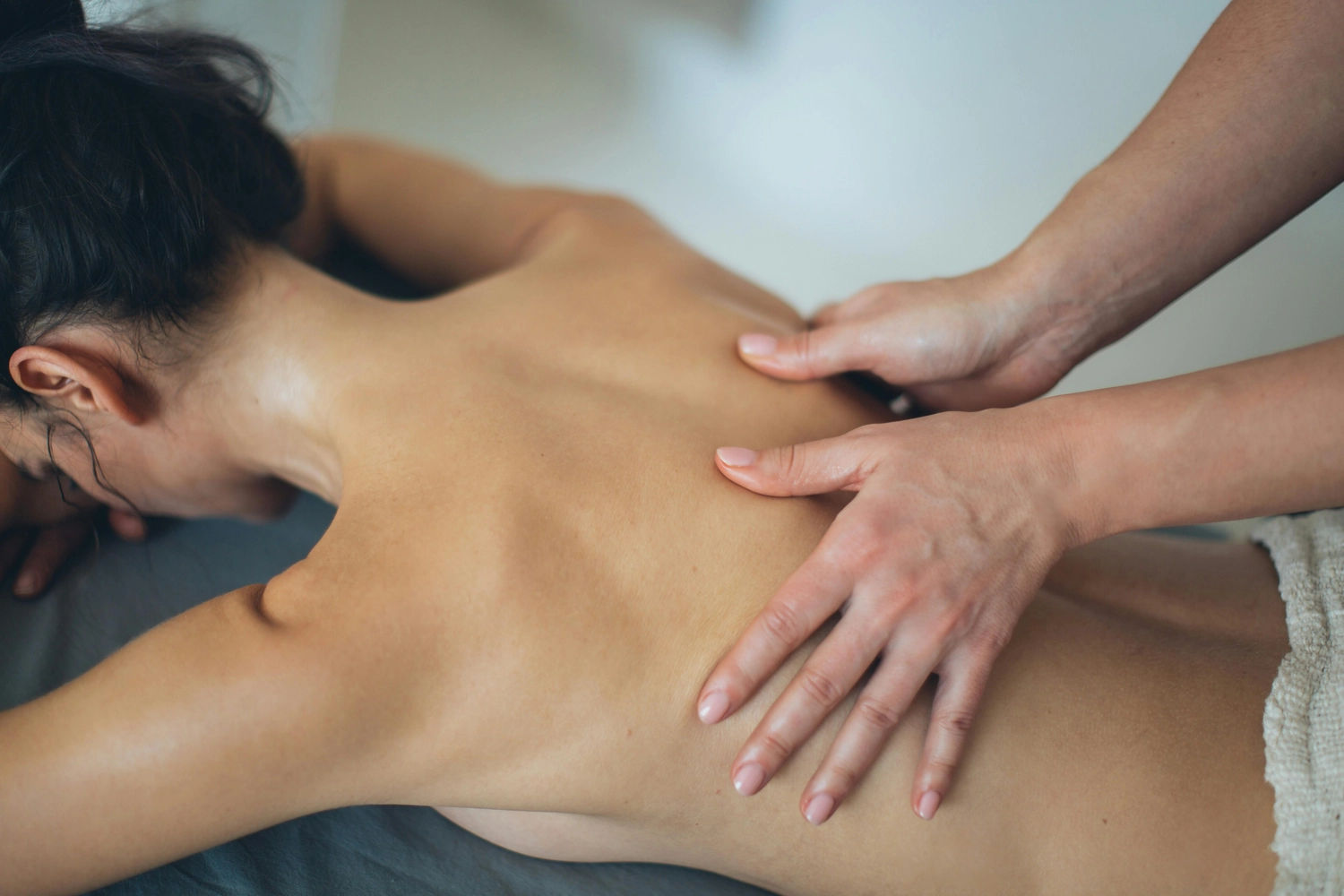 Osteopathie am Park - Ganzheitliche Behandlung - Dieses Bild zeigt eine Person, die eine therapeutische Massage am oberen Rücken und an den Schultern erhält.